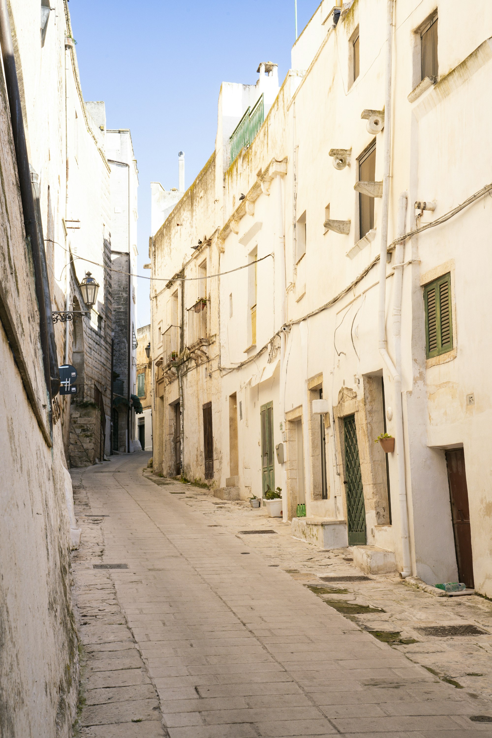 Quiet whitewashed alley in Puglia, Italy in soft afternoon light
